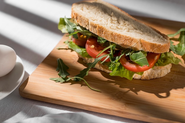 Sándwich de pan tostado con tomates, verduras y huevo de alto ángulo