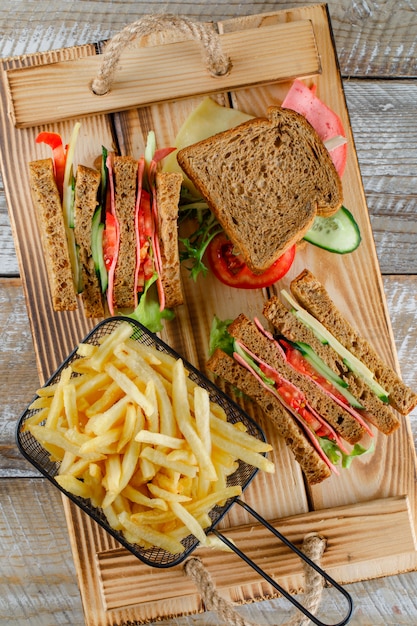 Sandwich con papas fritas vista superior en bandeja de madera