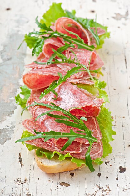 Sandwich con salami, lechuga, tomate y rúcula