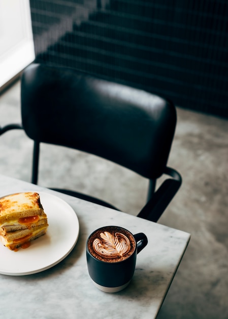 Sándwich y una taza de café en una mesa