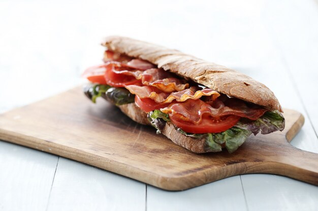 Sandwich de tocino en tabla de cortar de madera