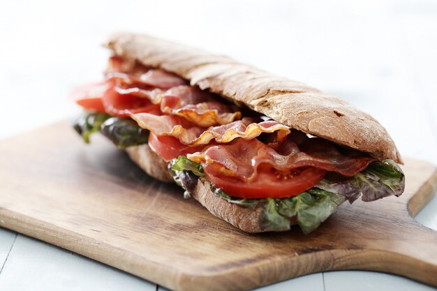 Sandwich de tocino en tabla de cortar de madera