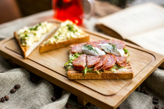 Sandwich con tostadas de salami pan lechuga salchicha crema agria eneldo vista lateral