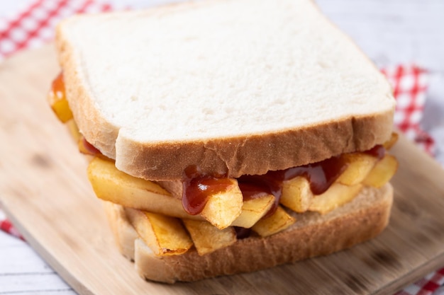 Foto gratuita sándwich tradicional británico de papas fritas con mantequilla en una mesa de madera