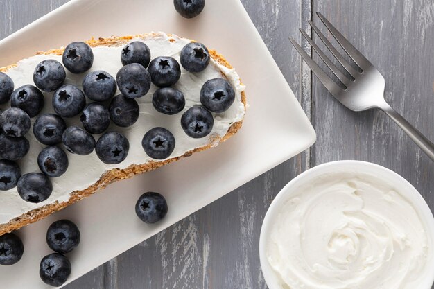 Sándwich de vista superior con queso crema y arándanos en placa