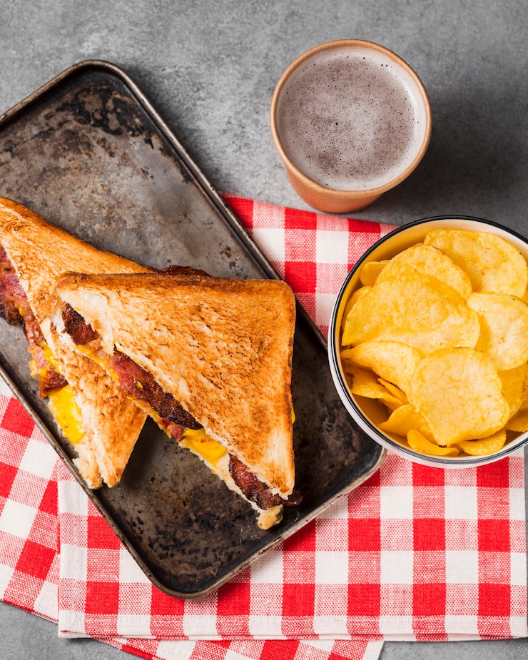 Foto gratuito sándwich de vista superior con tocino y queso con patatas fritas