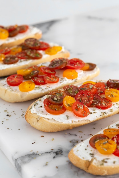 Sándwiches de alto ángulo con queso crema y tomates en mármol