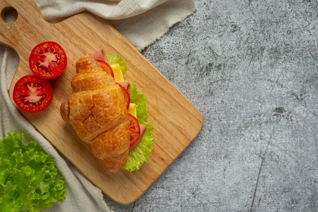 Foto gratuita sándwiches de croissant sobre superficie de madera oscura.