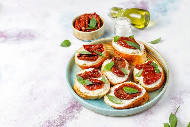 Sándwiches italianos: bruschetta con queso, tomates secos y albahaca.