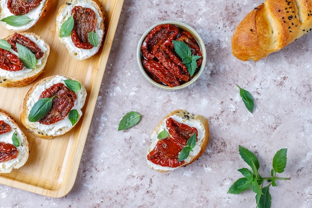 Sándwiches italianos: bruschetta con queso, tomates secos y albahaca