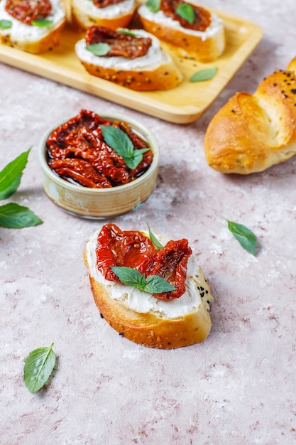 Sándwiches italianos: bruschetta con queso, tomates secos y albahaca.