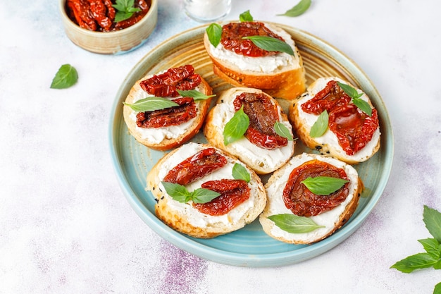 Sándwiches italianos: bruschetta con queso, tomates secos y albahaca.