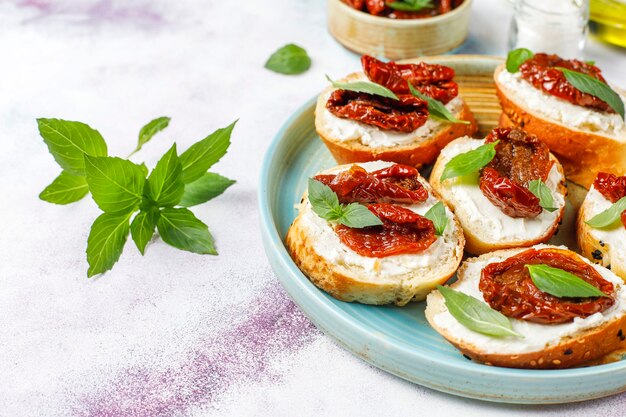 Sándwiches italianos: bruschetta con queso, tomates secos y albahaca.