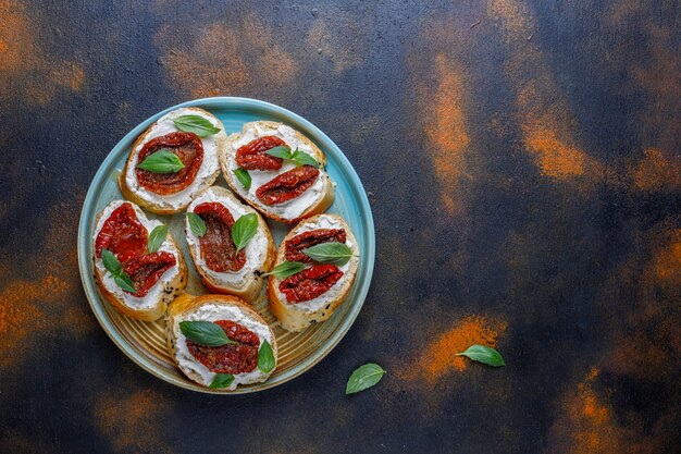 Sándwiches italianos: bruschetta con queso, tomates secos y albahaca.