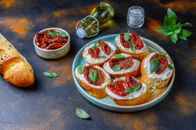 Sándwiches italianos: bruschetta con queso, tomates secos y albahaca.