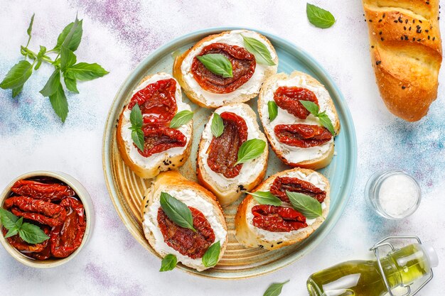 Sándwiches italianos: bruschetta con queso, tomates secos y albahaca.