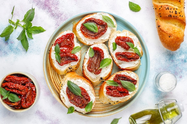 Sándwiches italianos: bruschetta con queso, tomates secos y albahaca.