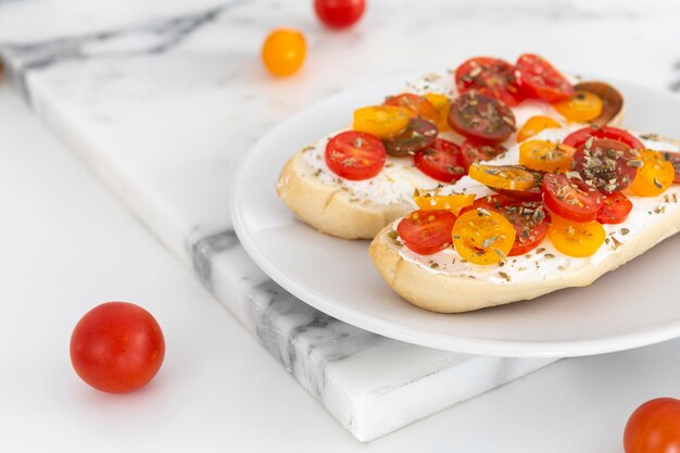 Sándwiches de primer plano con queso crema y tomates en placa