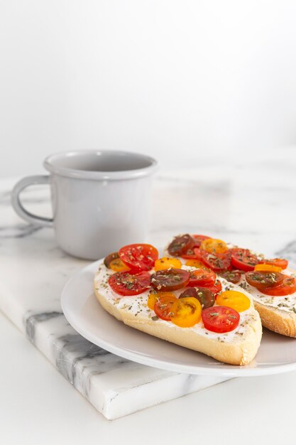 Sándwiches de queso crema y tomates con café