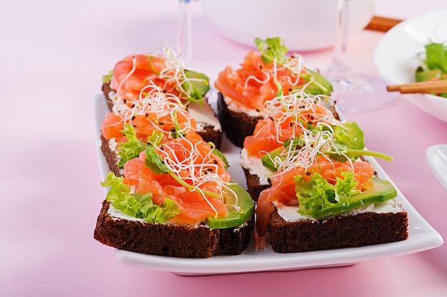 Sandwiches de salmón con queso crema y microverde. Canapé con salmón.