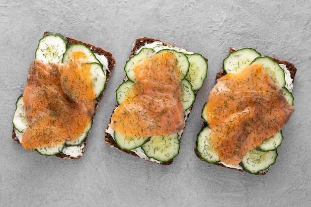 Foto gratuita sándwiches de vista superior con pepinos y salmón