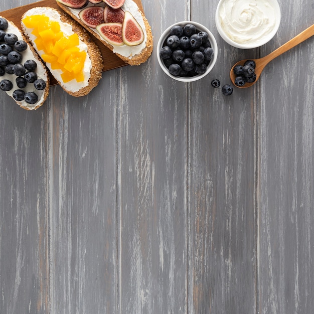 Foto gratuita sándwiches de vista superior con queso crema y frutas con espacio de copia