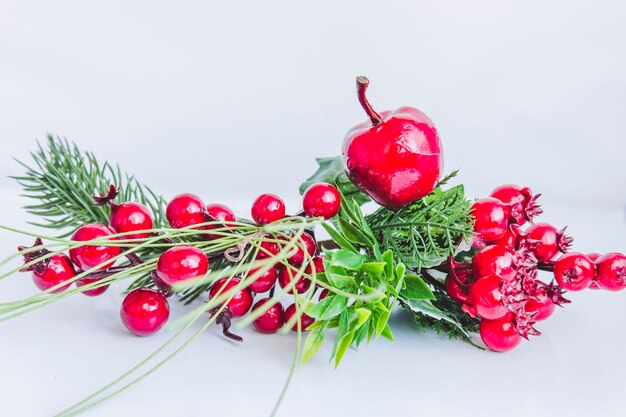 Santa bayas falsas y manzana sobre fondo blanco