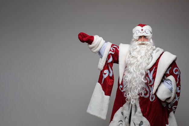 Santa Claus apuntando con la mano en el espacio vacío