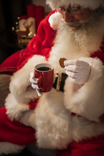 Foto gratuita santa claus bebiendo una taza de café