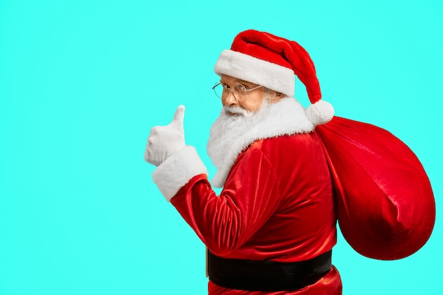 Santa Claus con bolsa mostrando el pulgar hacia arriba.