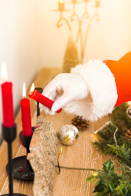 Santa claus encendiendo velas navideñas