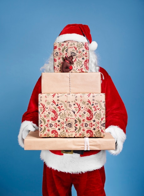 Foto gratuita santa claus con pila de regalos de navidad