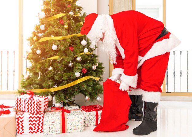 Santa Claus sacando regalos de la bolsa