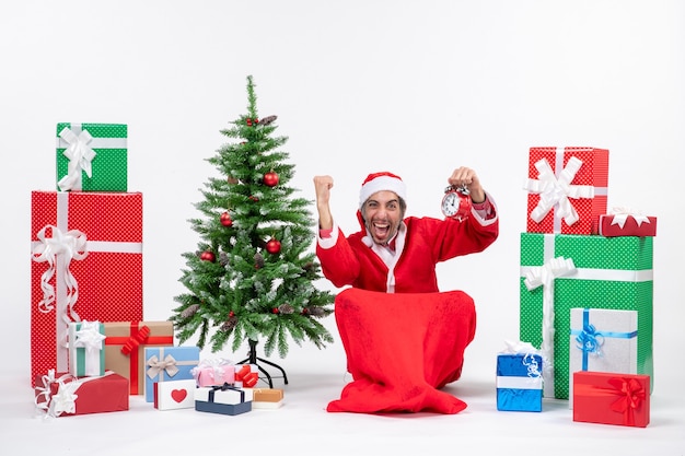 Foto gratuita santa claus sentado con cajas de regalo y árbol