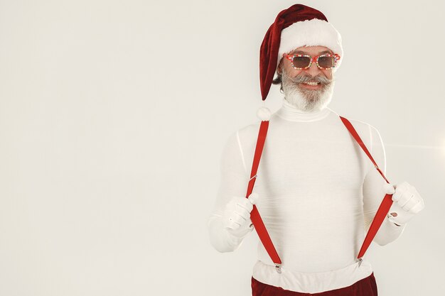 Santa de pelo gris de moda. El hombre usa ropa de punto. Abuelo con sombrero de santa.