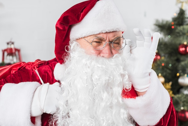 Santa en vasos cerca de árbol de navidad decorado