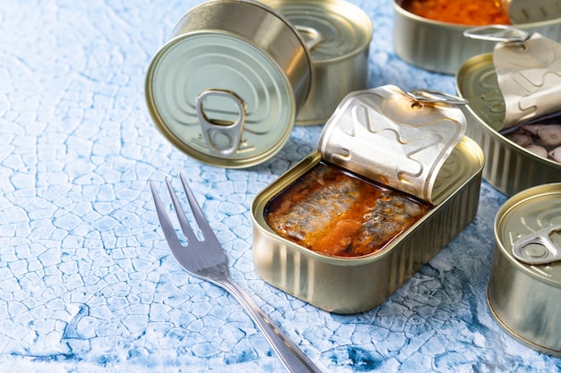 Foto gratuita sardinas enlatadas en lata de metal sobre un fondo azul