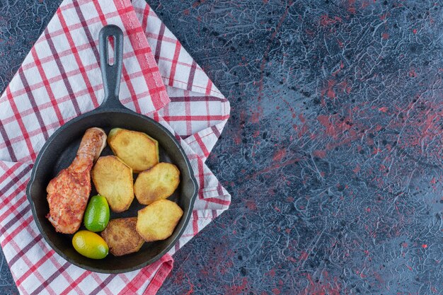 Una sartén con carne de pollo y verduras.