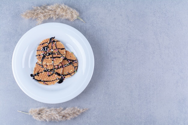 Una sartén de gofre rojizo redondo con chispas y crema