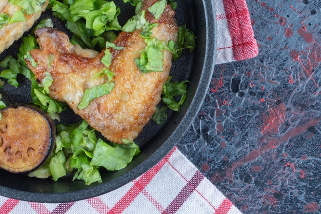 Una sartén de lechuga y carne de pollo al horno.