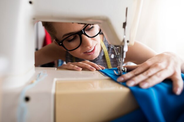 Sastre joven trabajando con máquina de coser