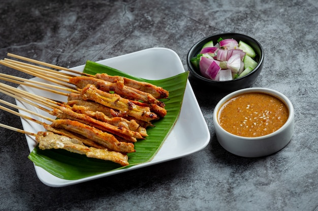 Satay de cerdo con salsa de maní o salsa agridulce, comida tailandesa