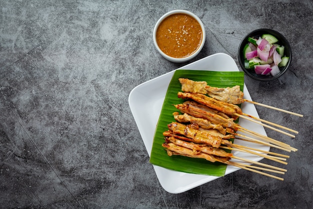 Satay de cerdo con salsa de maní o salsa agridulce, comida tailandesa