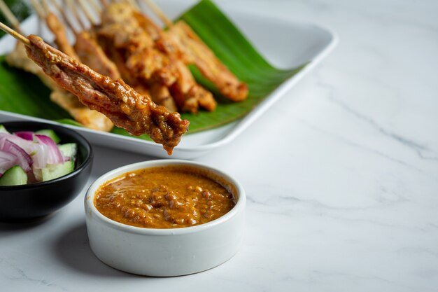 Satay de cerdo con salsa de maní o salsa agridulce, comida tailandesa