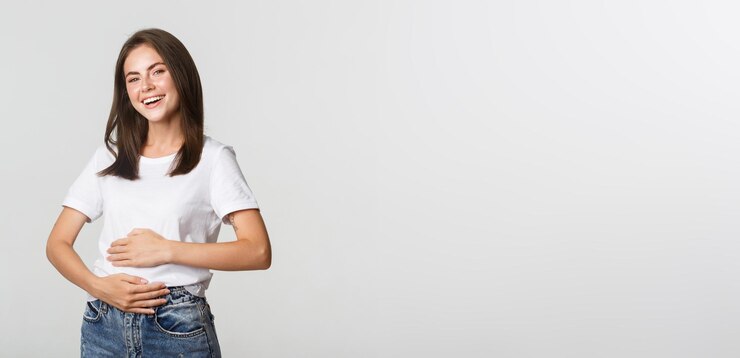 Satisfecho niña morena sonriente frotando el vientre después de comer comida deliciosa