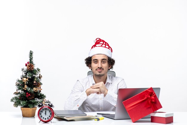 Satisfecho, ocupado, orgulloso, joven, hombre de negocios, con, divertido, santa claus, sombrero, celebrar, navidad, en, el, oficina, foto de stock, blanco, plano de fondo