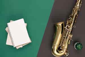 Foto gratuita saxofón sobre un fondo verde y una vista superior del bloc de notas
