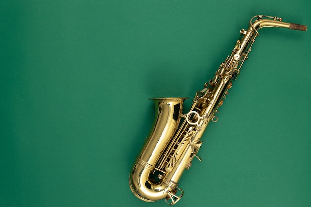 Foto gratuita saxofón en una vista superior de fondo verde
