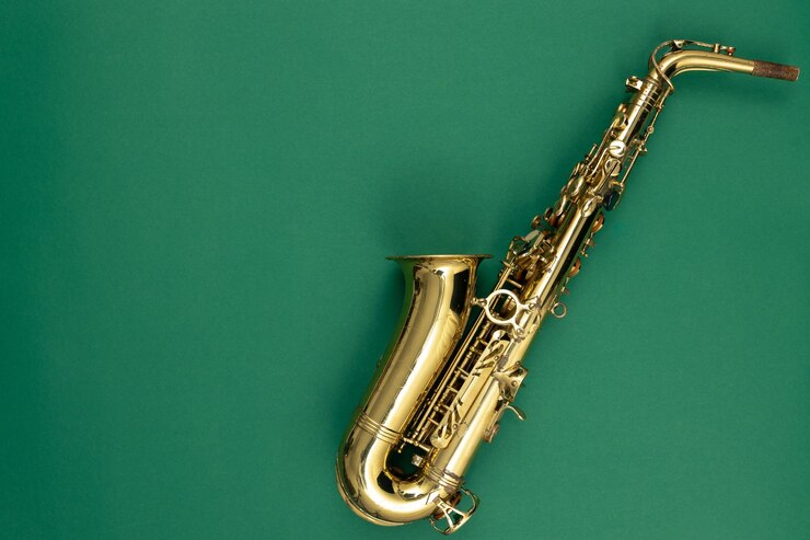 Foto gratuito saxofón en una vista superior de fondo verde