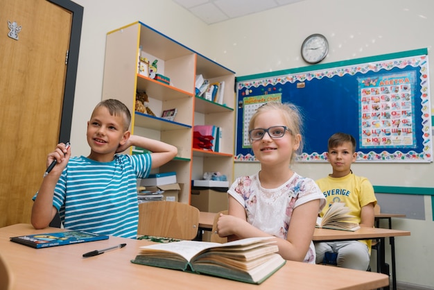 Foto gratuita schoolkids sentado en el aula sonriendo